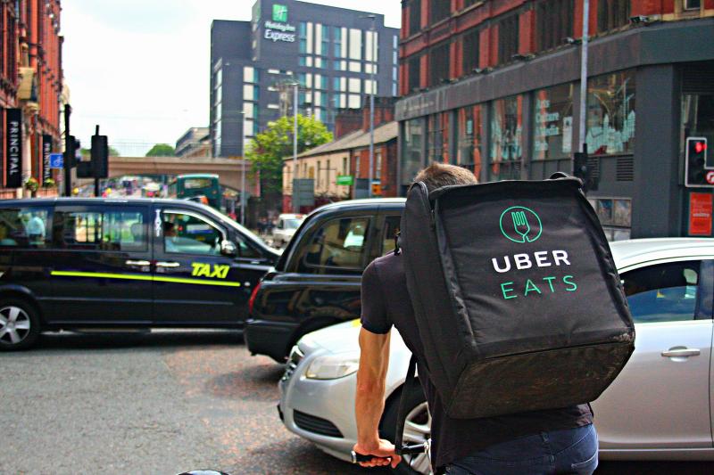 1599px-UBER_Eats_Delivery_Cyclist_Riding_Through_a_Busy_Oxford_Road_in_Manchester